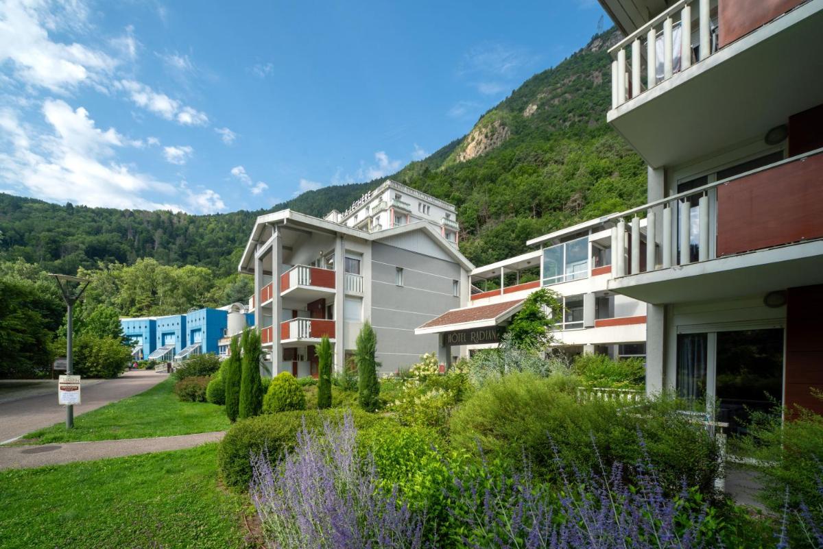 une rangée de bâtiments avec une montagne en arrière-plan dans l'établissement Residence RADIANA, à La Léchère