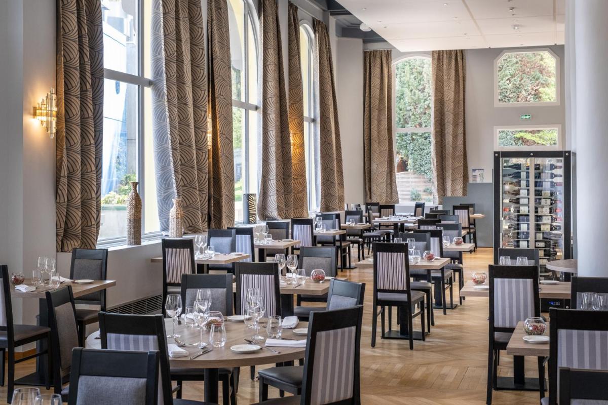 une salle à manger avec tables, chaises et fenêtres dans l'établissement Residence RADIANA, à La Léchère