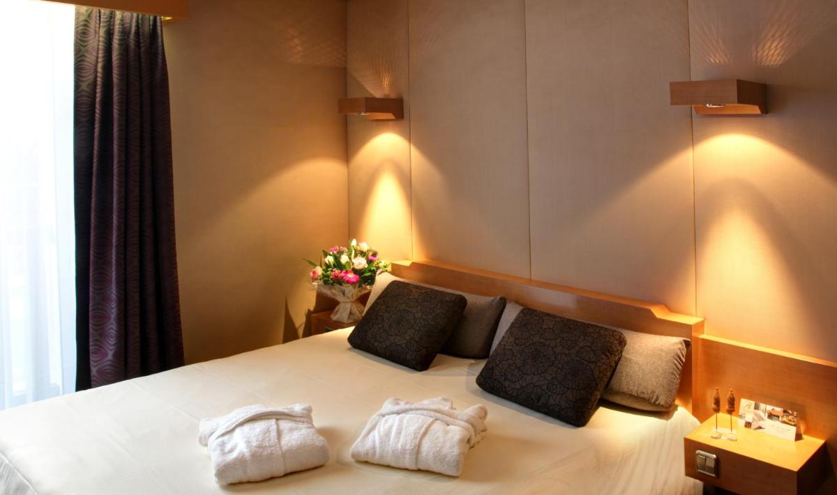 une chambre avec un lit avec deux oreillers dans l'établissement Amirauté Hôtel Golf Deauville, à Deauville