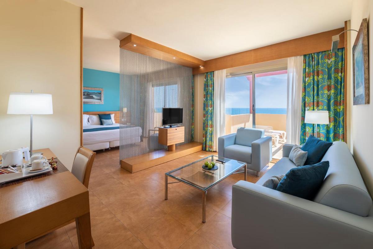 sala de estar con sofá y mesa en una habitación en Elba Carlota Beach & Golf Resort, en Caleta de Fuste