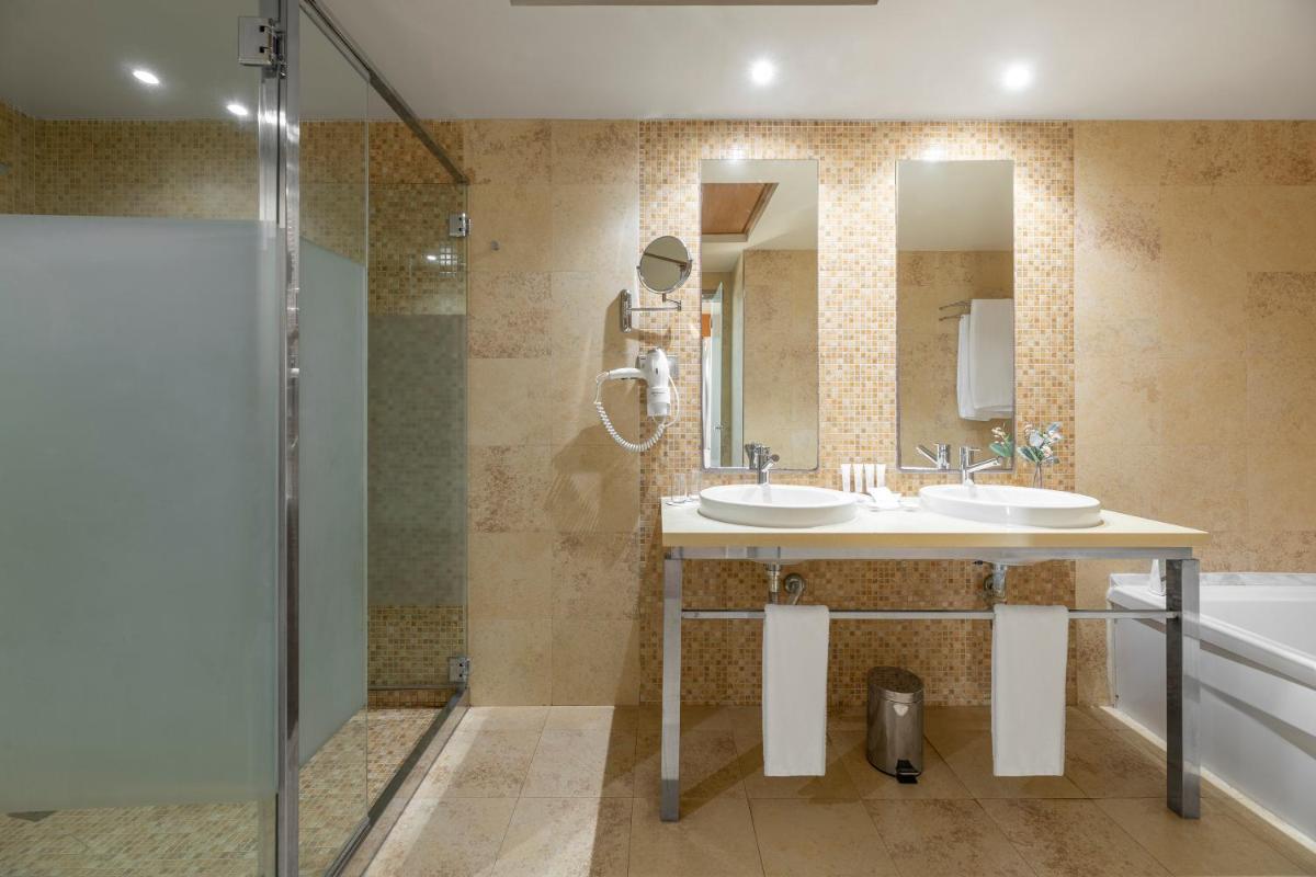 Un baño con dos lavabos y una ducha. en Elba Carlota Beach & Golf Resort, en Caleta de Fuste