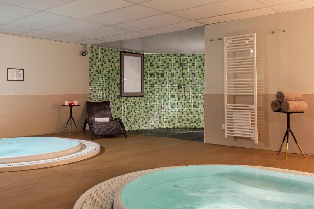 Elle comprend une grande salle de bains pourvue d'une grande baignoire. dans l'établissement SOWELL HOTELS Mont Blanc et SPA, à Saint-Gervais-les-Bains