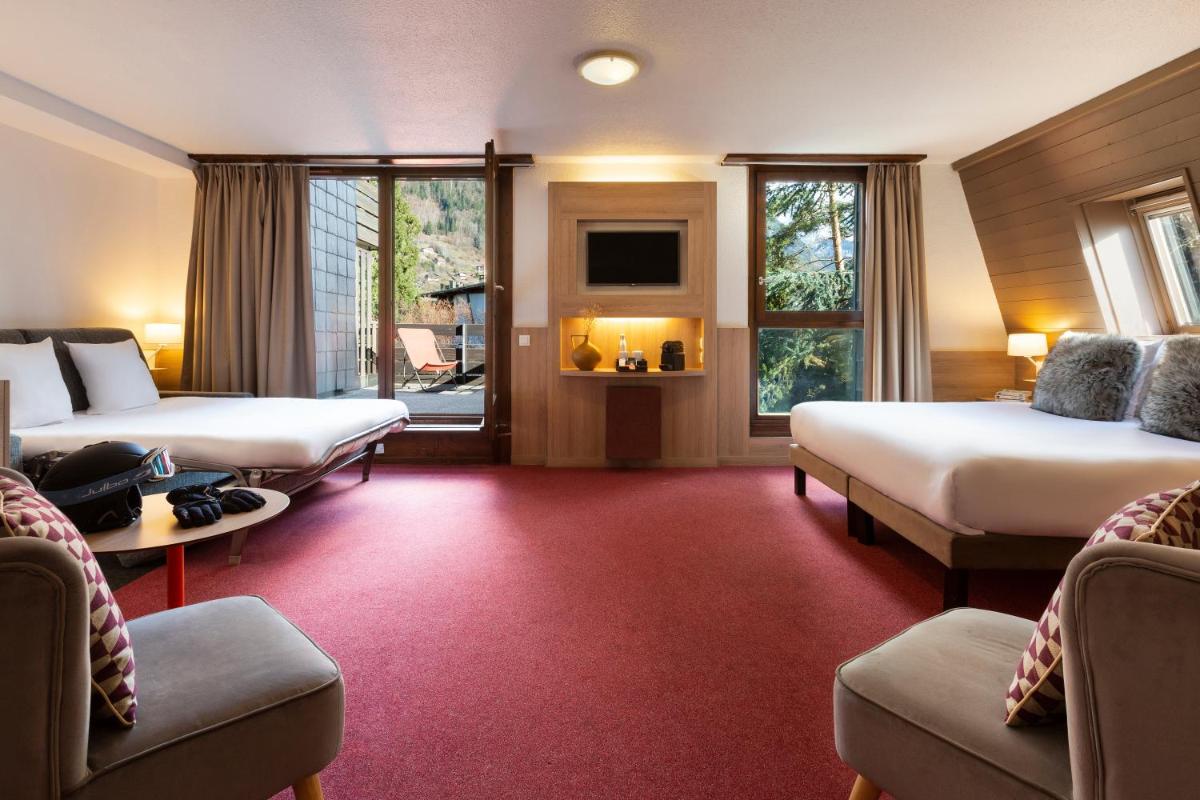 une chambre d'hôtel avec deux lits et un canapé dans l'établissement SOWELL HOTELS Mont Blanc et SPA, à Saint-Gervais-les-Bains