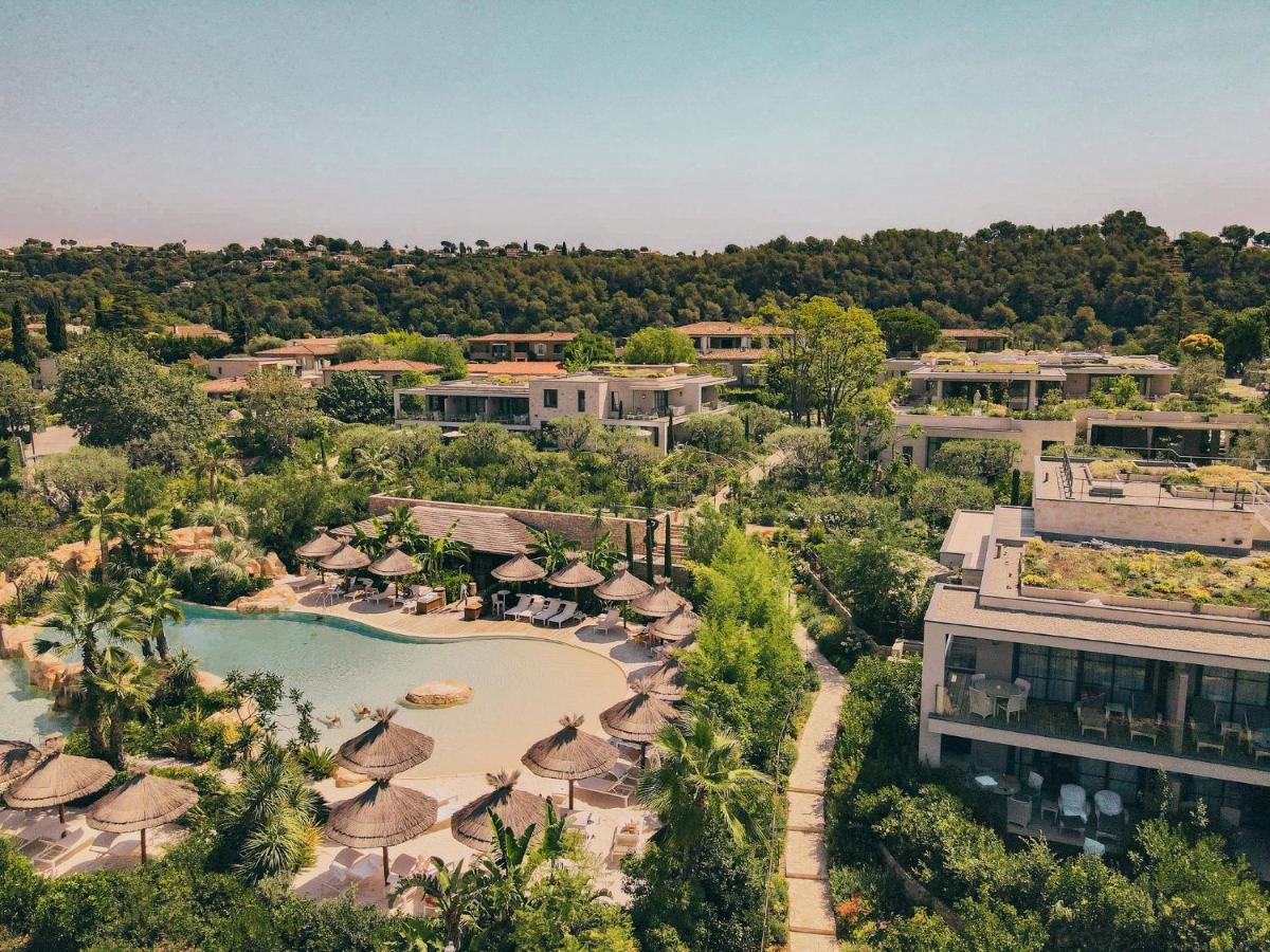 une vue aérienne d'un complexe hôtelier avec piscine et parasols dans l'établissement Domaine du Mas De Pierre, à Saint-Paul-de-Vence
