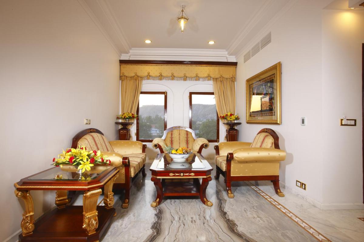a living room with three chairs and a table at The Raj Palace (Small Luxury Hotels of the World) in Jaipur