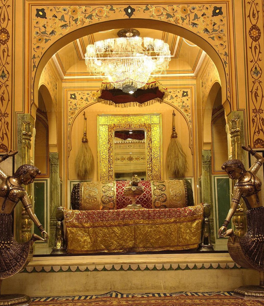 a room with a chandelier and a large bed at The Raj Palace (Small Luxury Hotels of the World) in Jaipur