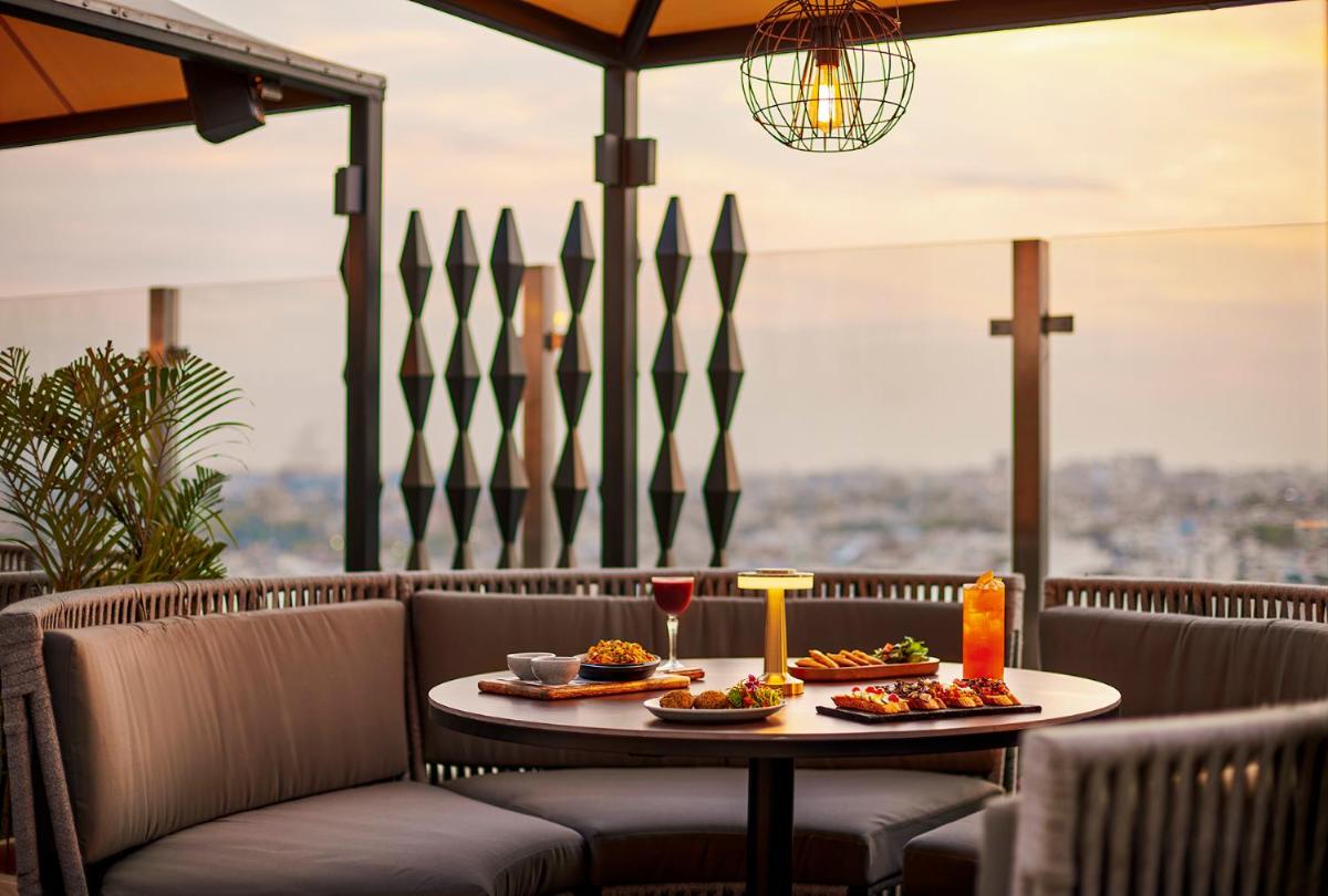 a table with food and drinks on a patio at Hyatt Place Jaipur Malviya Nagar in Jaipur a table with food and drinks on a patio at Hyatt Place Jaipur Malviya Nagar in Jaipur