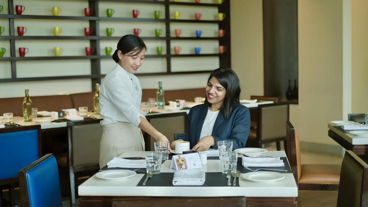 two women sitting at a table in a restaurant at Holiday Inn Chennai OMR IT Expressway by IHG in Chennai