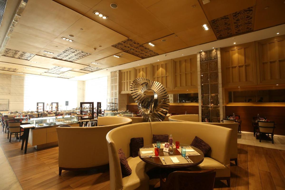 a restaurant with chairs and a table and a restaurant at Crowne Plaza New Delhi Mayur Vihar Noida by IHG in New Delhi