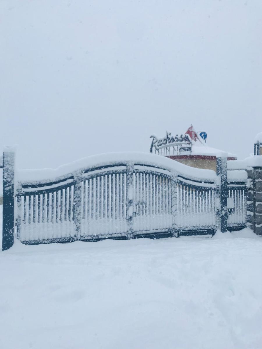 a fence covered in snow in a yard at Radisson Kufri in Shimla