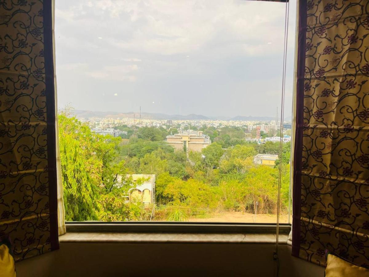a window with a view of a city at The Lalit Laxmi Vilas Palace in Udaipur