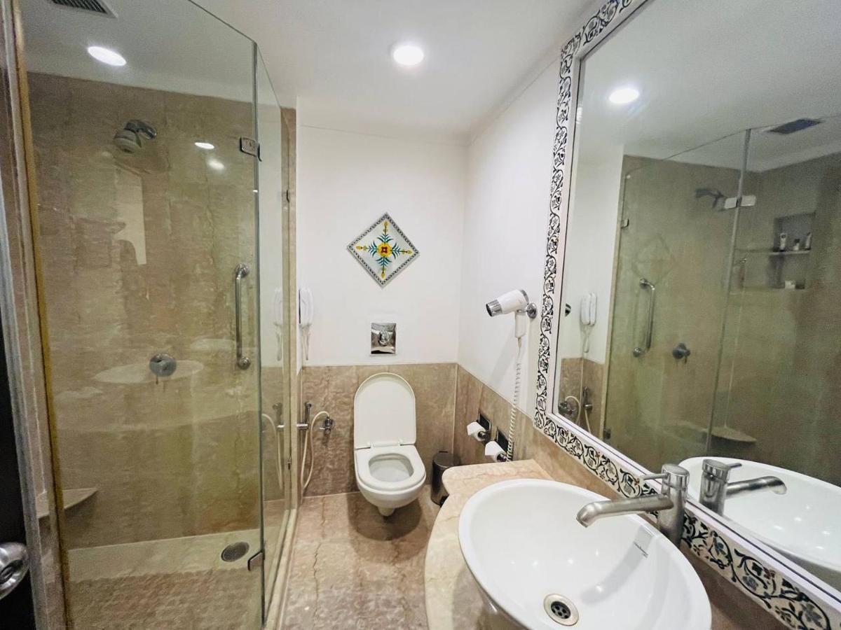 a bathroom with a toilet and a sink and a shower at The Lalit Laxmi Vilas Palace in Udaipur