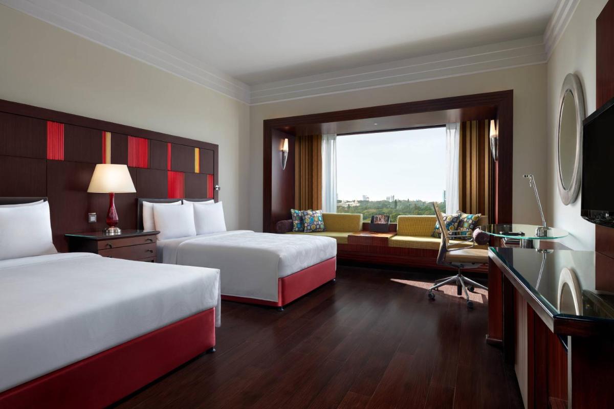 a hotel room with two beds and a couch at JW Marriott Hotel Bengaluru in Bengaluru