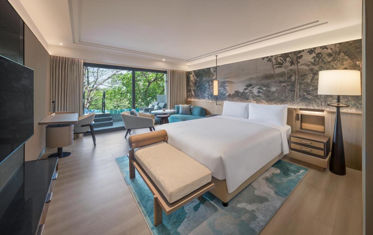 a bedroom with a large bed and a living room at JW Marriott Goa in Vagator a bedroom with a large bed and a living room at JW Marriott Goa in Vagator