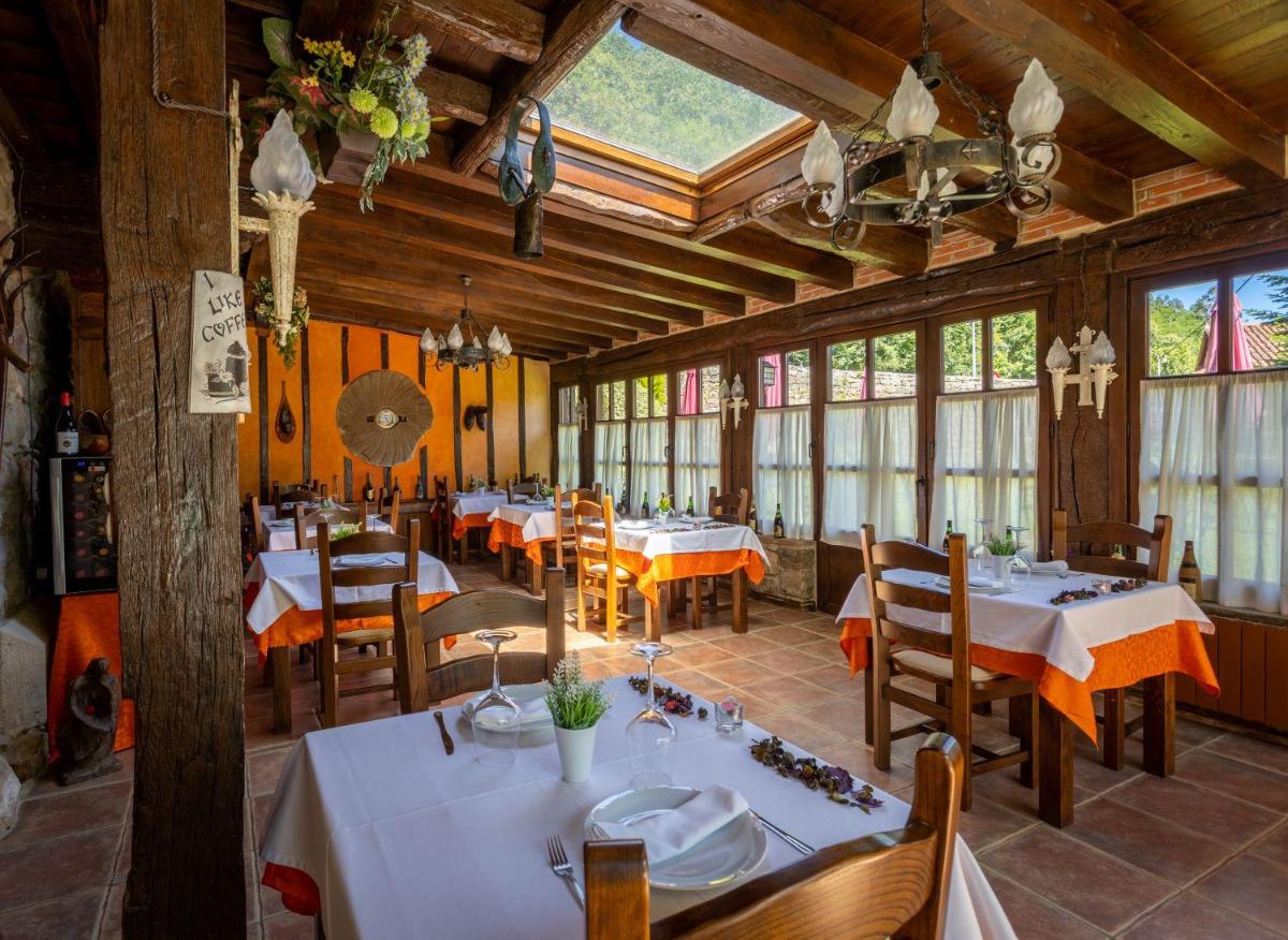 Un comedor con mesas y sillas y ventanas. en Hotel Spa Casona La Hondonada, en Terán
