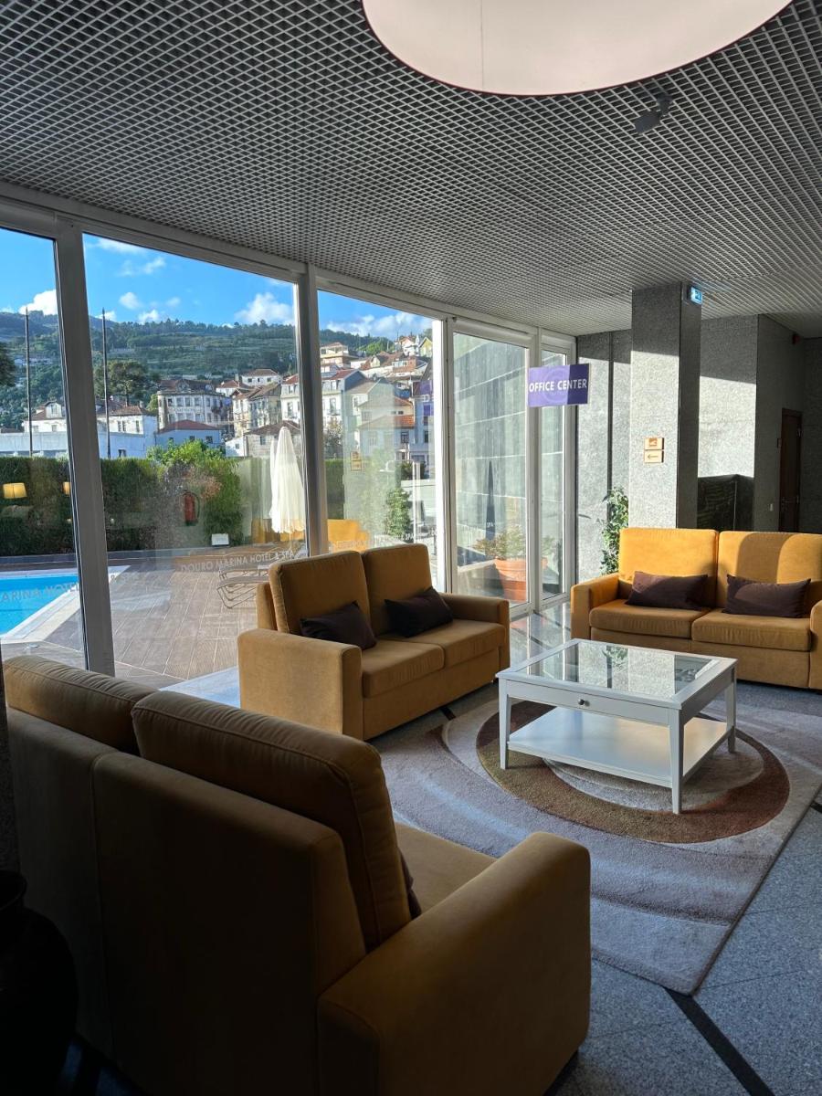 uma sala de estar com sofás e uma mesa num edifício em Douro Marina Hotel & SPA em Resende