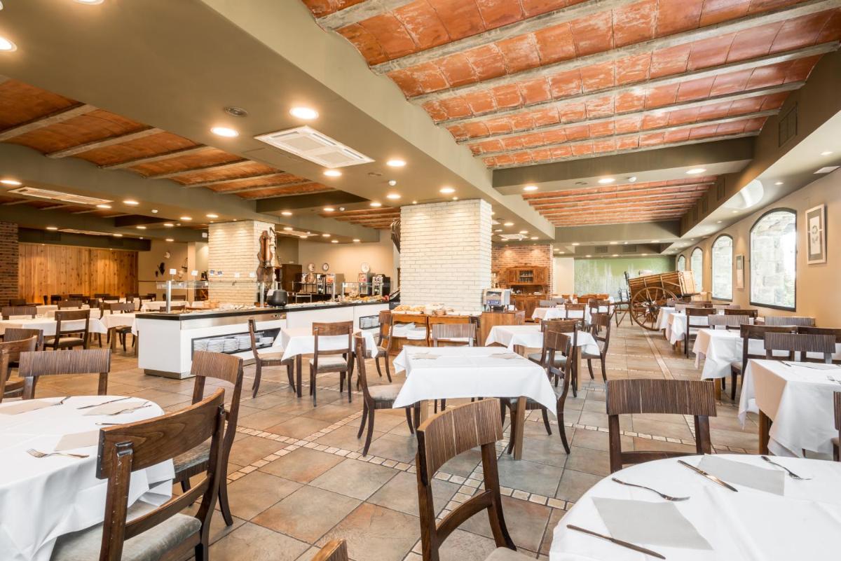 Un restaurante con mesas y sillas blancas y un mostrador. en Snö Villa de Sallent 4, en Formigal