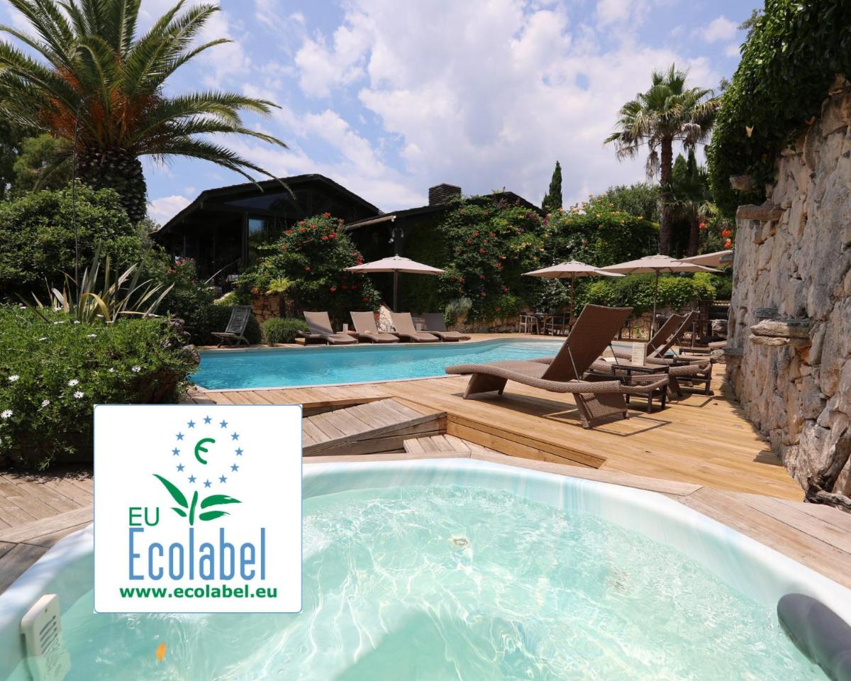 une piscine avec un panneau devant un complexe hôtelier dans l'établissement Lodge de Charme A Cheda, à Bonifacio