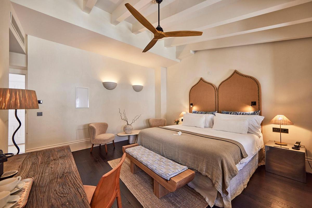 Un dormitorio con una cama grande y un ventilador de techo. en Puro Grand Hotel, en Palma de Mallorca