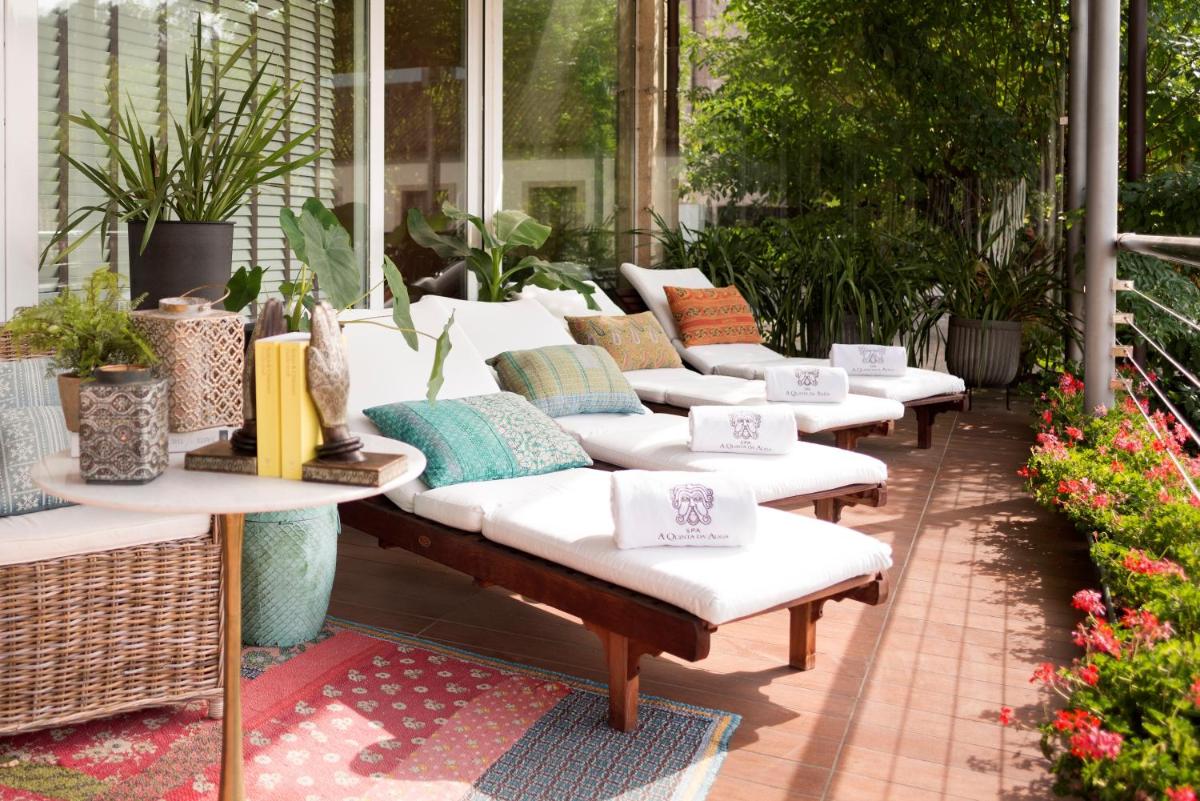 una fila de bancos con almohadas en un patio en A Quinta Da Auga Hotel Spa Relais & Chateaux, en Santiago de Compostela