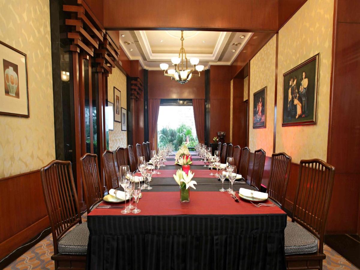 a long dining room with a long table with chairs at Eros Hotel New Delhi, Nehru Place in New Delhi a long dining room with a long table with chairs at Eros Hotel New Delhi, Nehru Place in New Delhi