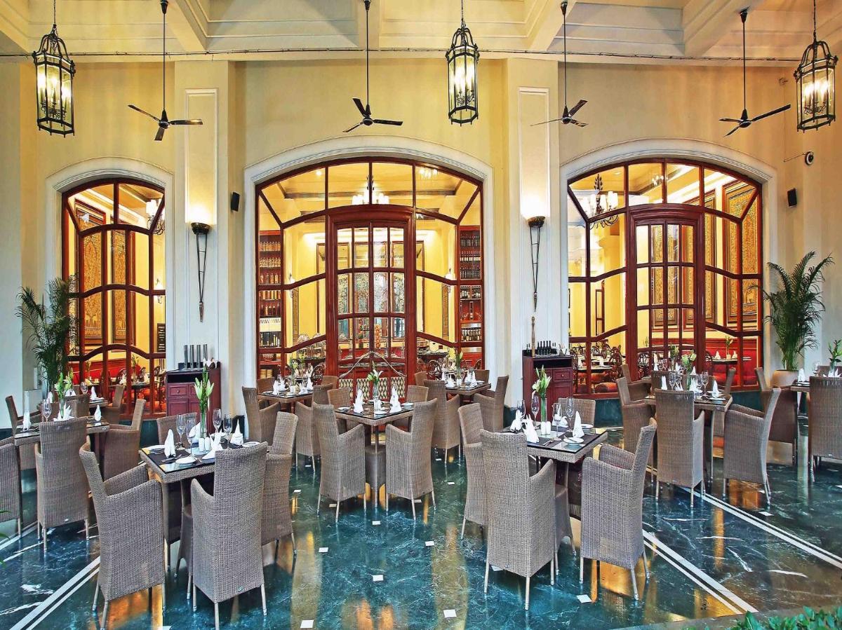 a restaurant with tables and chairs in a room at Eros Hotel New Delhi, Nehru Place in New Delhi a restaurant with tables and chairs in a room at Eros Hotel New Delhi, Nehru Place in New Delhi