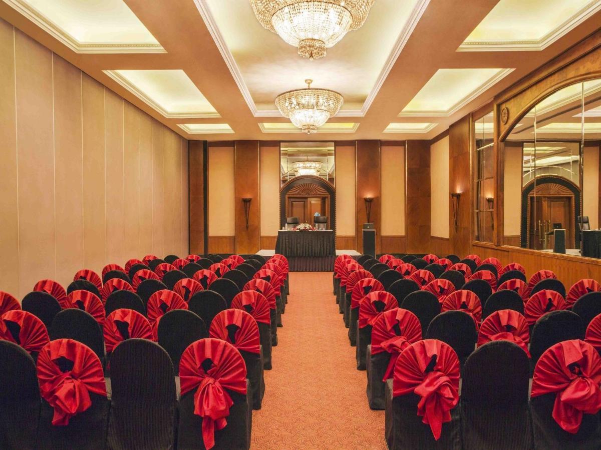 a room filled with chairs with red bows at Eros Hotel New Delhi, Nehru Place in New Delhi a room filled with chairs with red bows at Eros Hotel New Delhi, Nehru Place in New Delhi