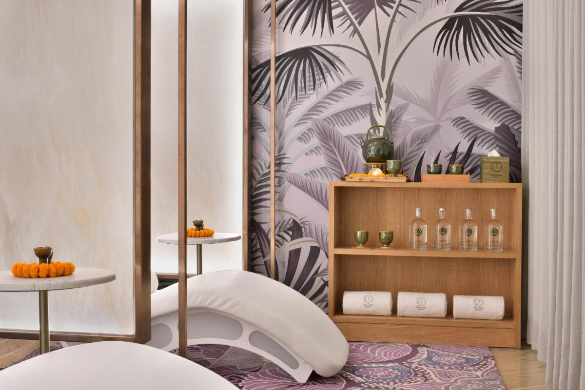 a bathroom with a toilet and a wall with palm leaves at Taj Mahal, New Delhi in New Delhi