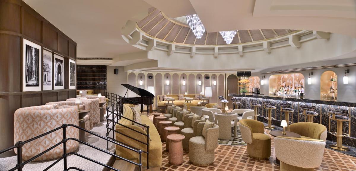 a restaurant with a row of chairs and a piano at Taj Mahal, New Delhi in New Delhi