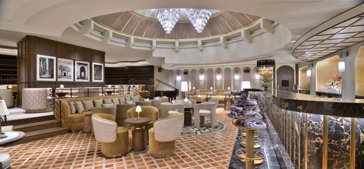 a hotel lobby with a bar with chairs and tables at Taj Mahal, New Delhi in New Delhi