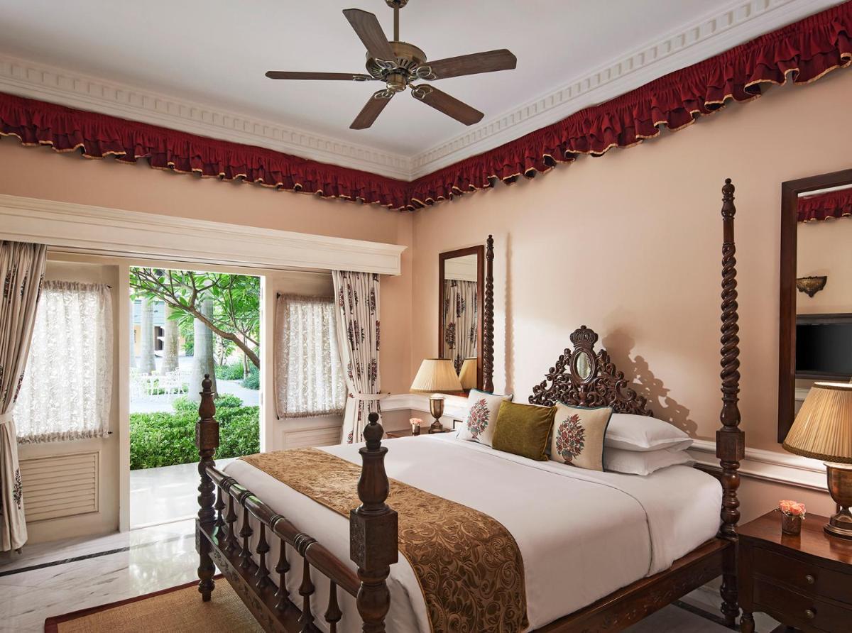 a bedroom with a large bed with a ceiling fan at Raajkutir - IHCL SeleQtions in Kolkata