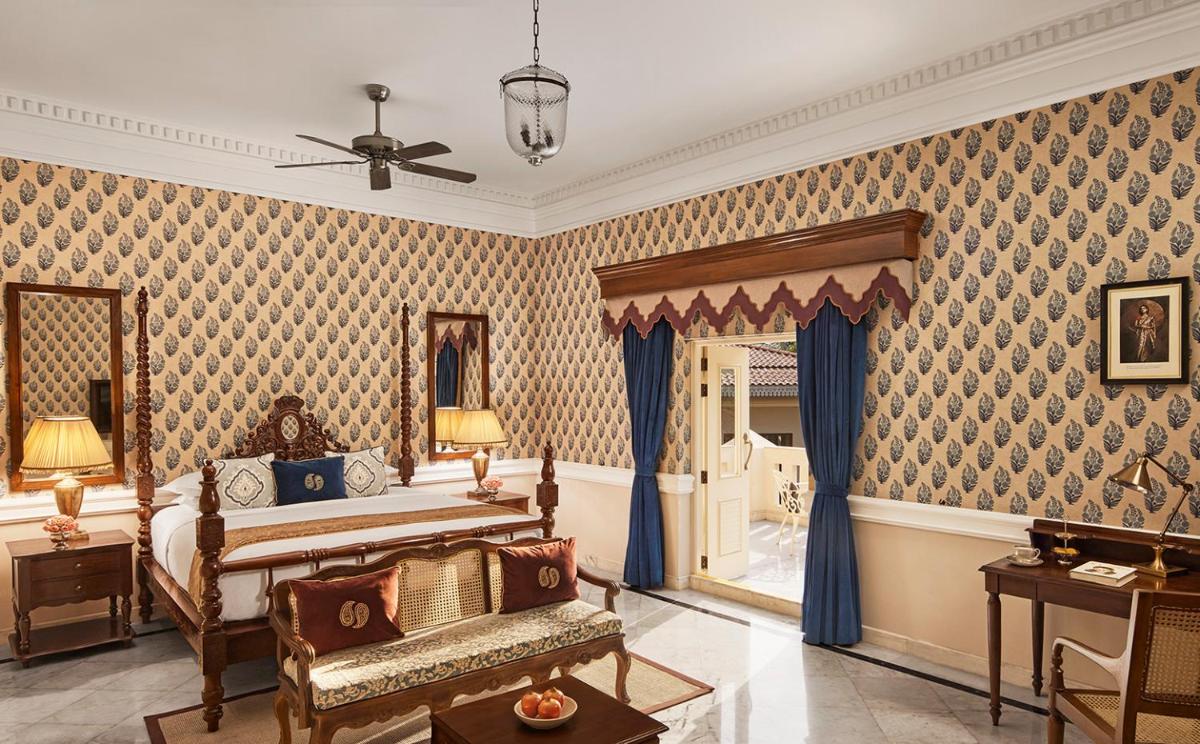 a bedroom with a king sized bed and blue wallpaper at Raajkutir - IHCL SeleQtions in Kolkata