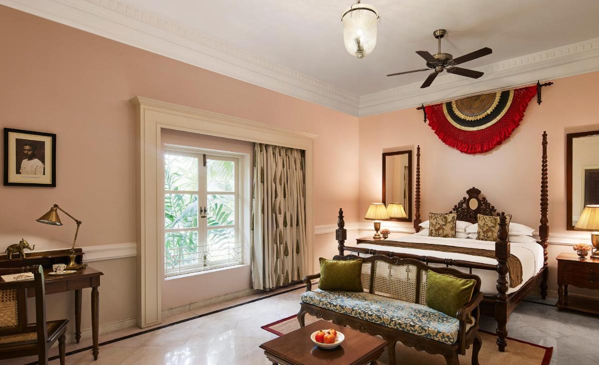 a bedroom with a bed and a chair and a window at Raajkutir - IHCL SeleQtions in Kolkata