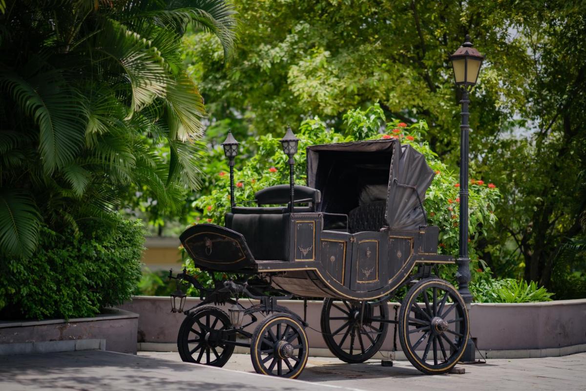 an old black carriage with a person sitting in it at Raajkutir - IHCL SeleQtions in Kolkata