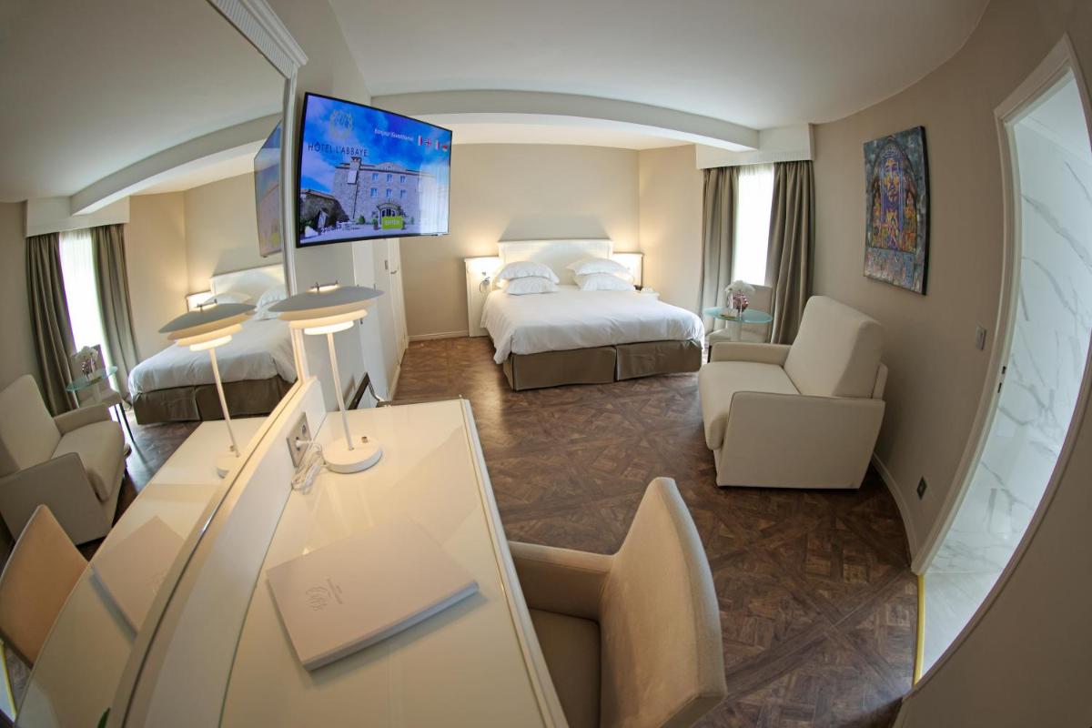 Un ou plusieurs lits dans un hébergement de l'établissement Hôtel L'Abbaye