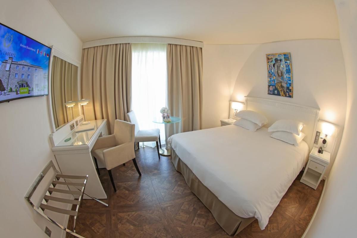 Un ou plusieurs lits dans un hébergement de l'établissement Hôtel L'Abbaye