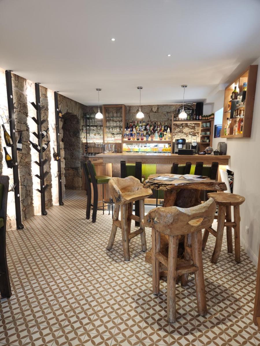 un restaurant avec des tables et des chaises en bois ainsi qu'un bar dans l'établissement Hôtel Casale Olmia, à Moncale
