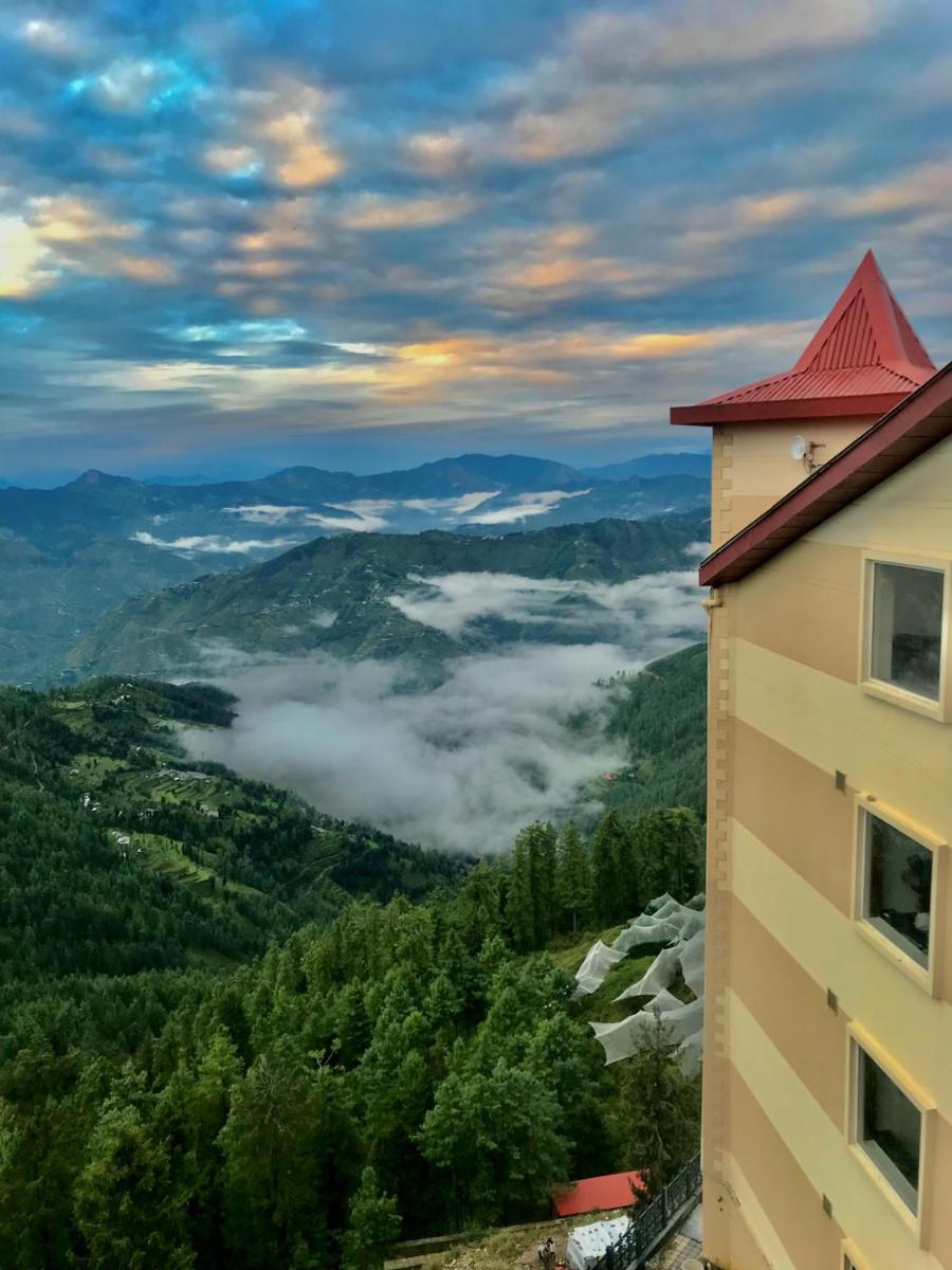 a view of a mountain with clouds in the valley at Radisson Kufri in Shimla