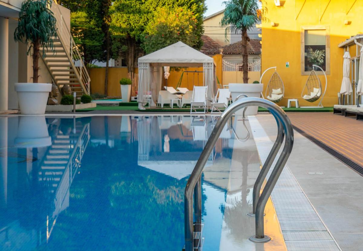 uma piscina com uma escadaria que leva a uma casa em Hotel de Ilhavo Plaza & Spa em Ílhavo