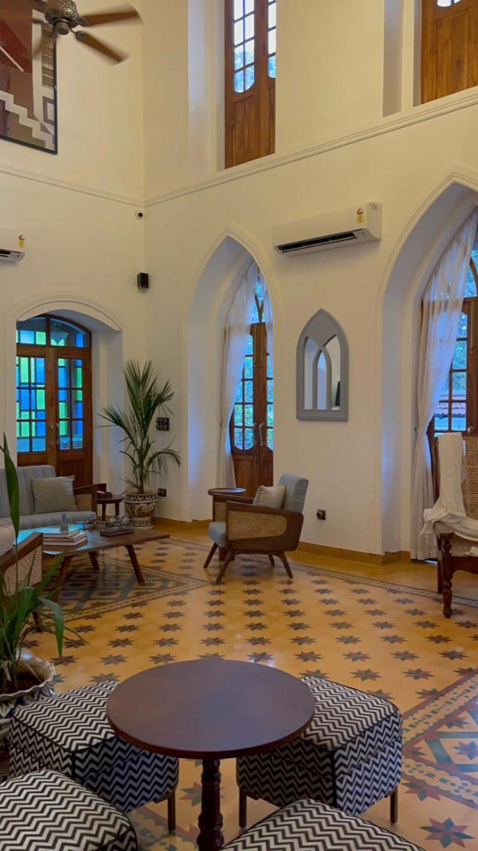 a living room with a table and chairs in a room at The Postcard Saligao in Calangute