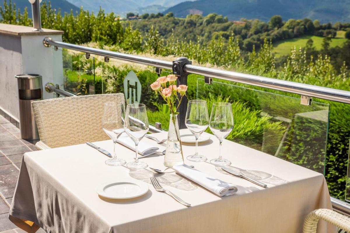 una mesa con copas de vino y servilletas en el balcón en Hosteria de Torazo Nature Hotel & Spa, en Torazo 194 fotos más