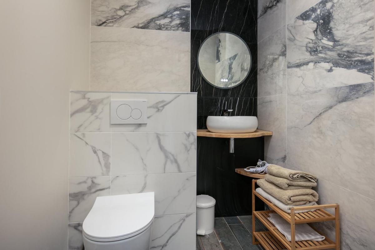 une salle de bain avec des toilettes blanches et un miroir dans l'établissement Résidence Bellevue, à Camaret-sur-Mer 28 autres photos