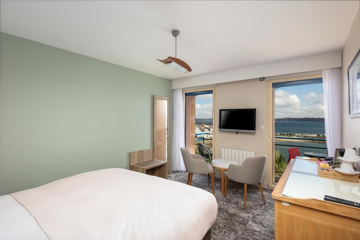 une chambre avec un lit, un bureau et une télévision dans l'établissement Résidence Bellevue, à Camaret-sur-Mer