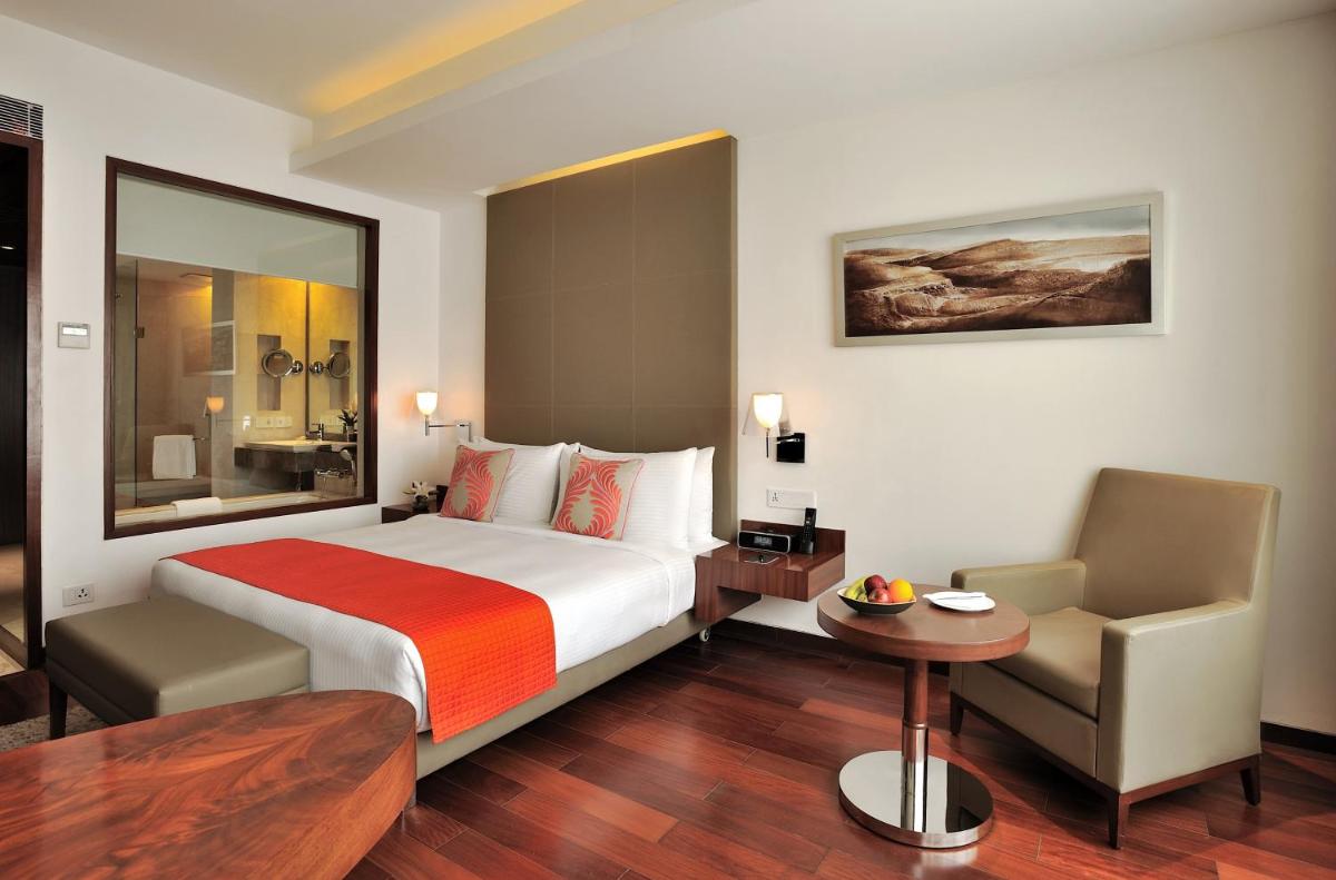a hotel room with a bed and a chair at The Anya Hotel-Golf Course Road in Gurgaon +60 photos
