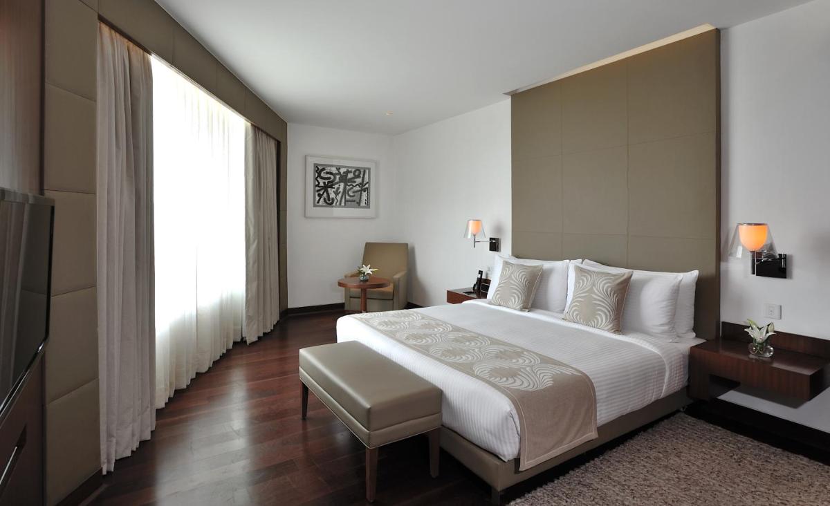 a bedroom with a large bed and a large window at The Anya Hotel-Golf Course Road in Gurgaon