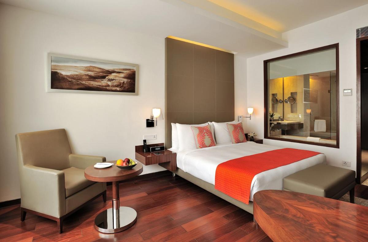 a hotel room with a bed and a chair at The Anya Hotel-Golf Course Road in Gurgaon