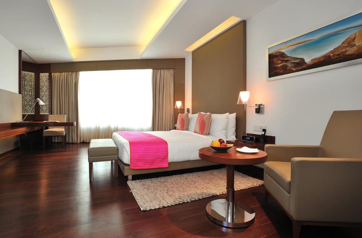 a hotel room with a bed and a couch and a table at The Anya Hotel-Golf Course Road in Gurgaon