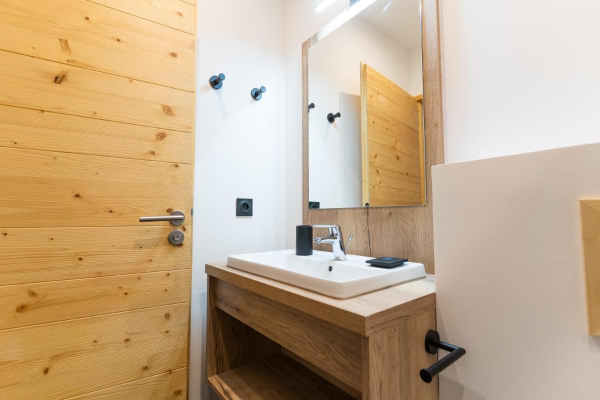 une salle de bains avec un lavabo et un miroir dans l'établissement Les Roches du Mont Blanc - Résidence & Spa, à Combloux