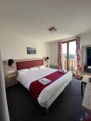 une chambre d'hôtel avec un grand lit et une fenêtre dans l'établissement Hôtel Espace Montclar, à Montclar