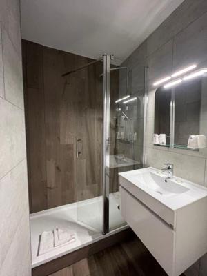 une salle de bains avec baignoire, lavabo et douche dans l'établissement Hôtel Espace Montclar, à Montclar